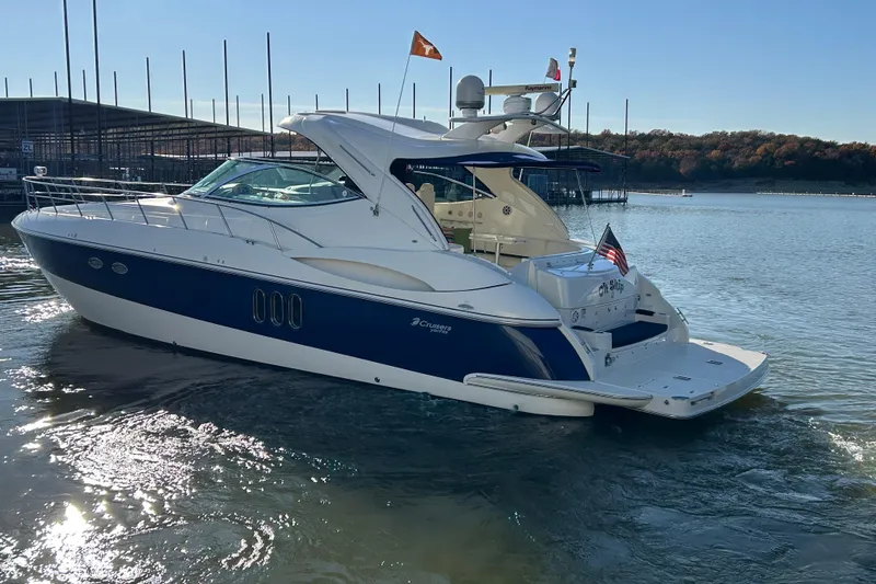 Slide: The Image of Luxury 2005 Cruisers 500 yacht on serene lake with clear blue sky. - 8
