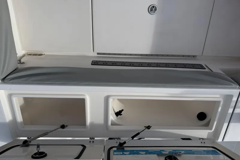 Slide: The Image of 2004 Regulator 24 Forward Seating boat interior with storage compartments and measuring scale. - 15