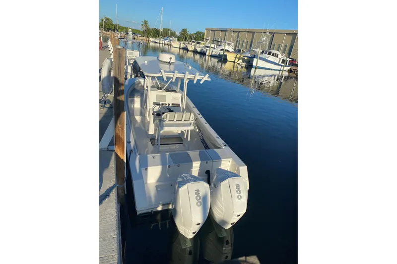 Slide: The Image of 2004 Regulator 24 Forward Seating boat docked at marina with twin engines. - 2