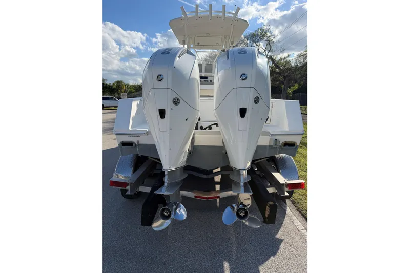 Slide: The Image of 2004 Regulator 24 Forward Seating boat with dual outboard engines on a trailer. - 4