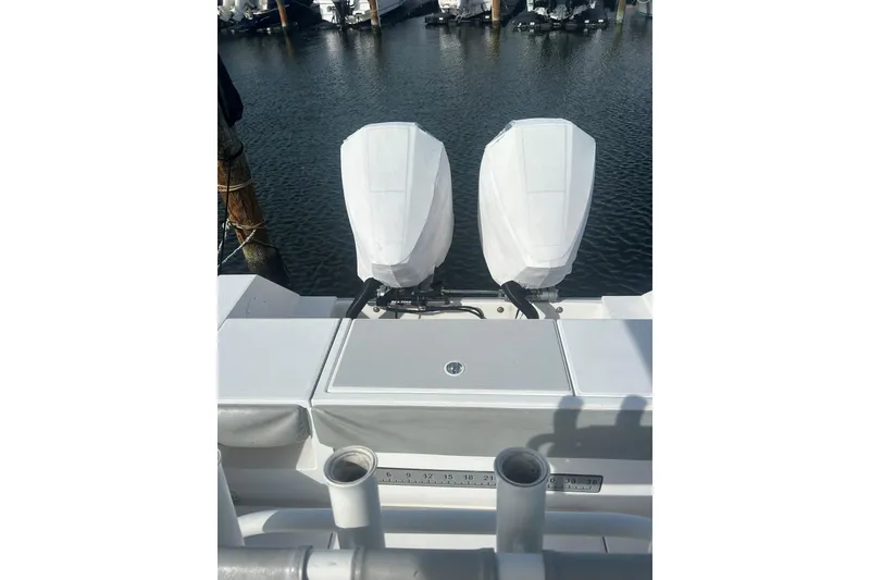 Slide: The Image of 2004 Regulator 24 Forward Seating boat with dual covered outboard motors at dock. - 6