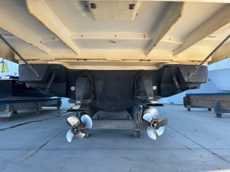 Slide: The Image of 2016 Regal 35 Sport Coupe boat underside with dual propellers in a dry dock setting. - 14