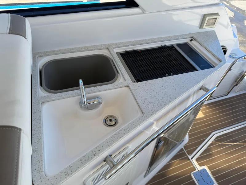 Slide: The Image of 2016 Regal 35 Sport Coupe yacht kitchenette with sink and grill on deck. - 20