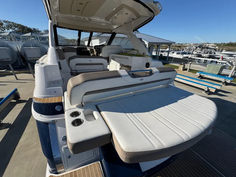 Slide: The Image of 2016 Regal 35 Sport Coupe boat with spacious seating and modern design at a marina. - 35