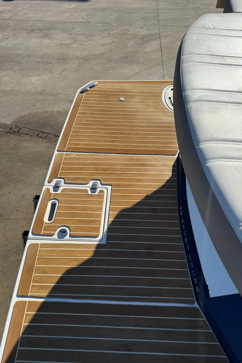 Slide: The Image of 2016 Regal 35 Sport Coupe boat deck with teak flooring and cushioned seating. - 42