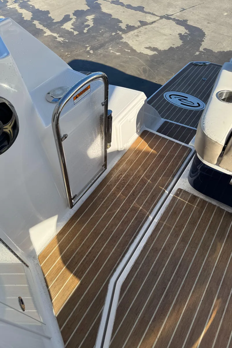Slide: The Image of 2016 Regal 35 Sport Coupe boat deck with wood finish and stainless steel railing. - 44