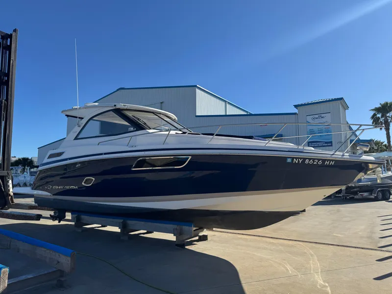 Slide: The Image of 2016 Regal 35 Sport Coupe boat on dry dock under clear blue sky. - 8