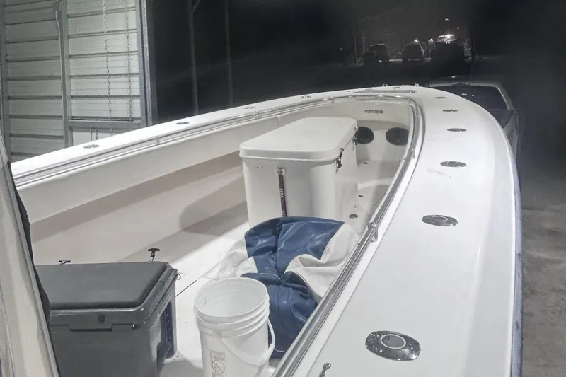Slide: The Image of 2005 Contender 35 ST boat interior with cooler and bucket in storage area. - 3