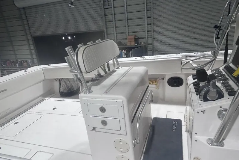 Slide: The Image of 2005 Contender 35 ST boat interior with helm, seating, and storage compartments in a garage. - 4