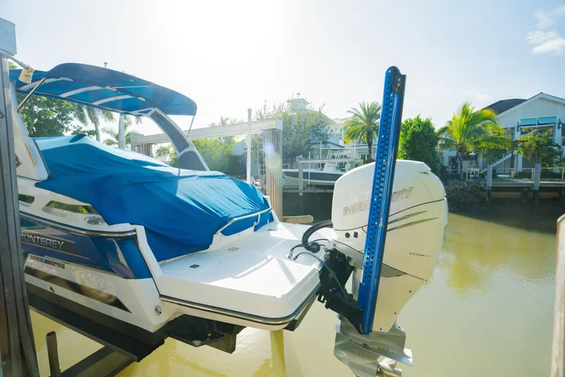 Slide: The Image of 2021 Monterey 255SS Super Sport boat docked with blue cover and Mercury outboard motor. - 10