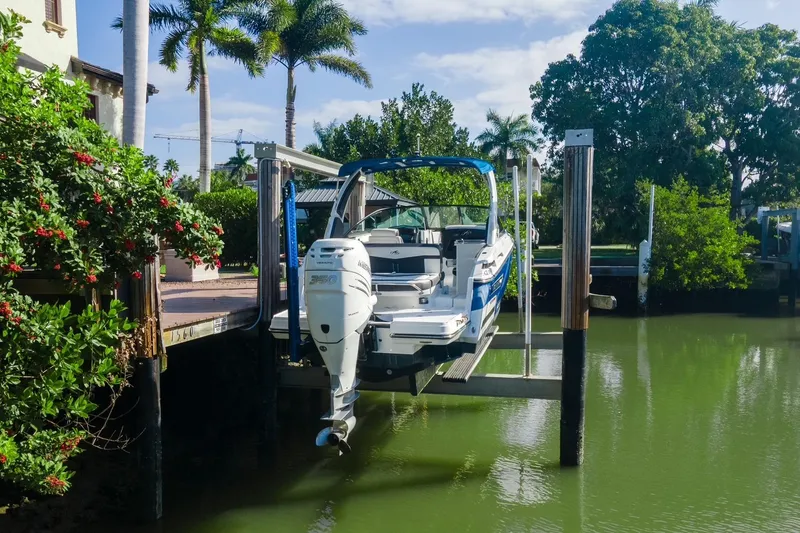 Slide: The Image of 2021 Monterey 255SS Super Sport boat docked near lush greenery and palm trees. - 16
