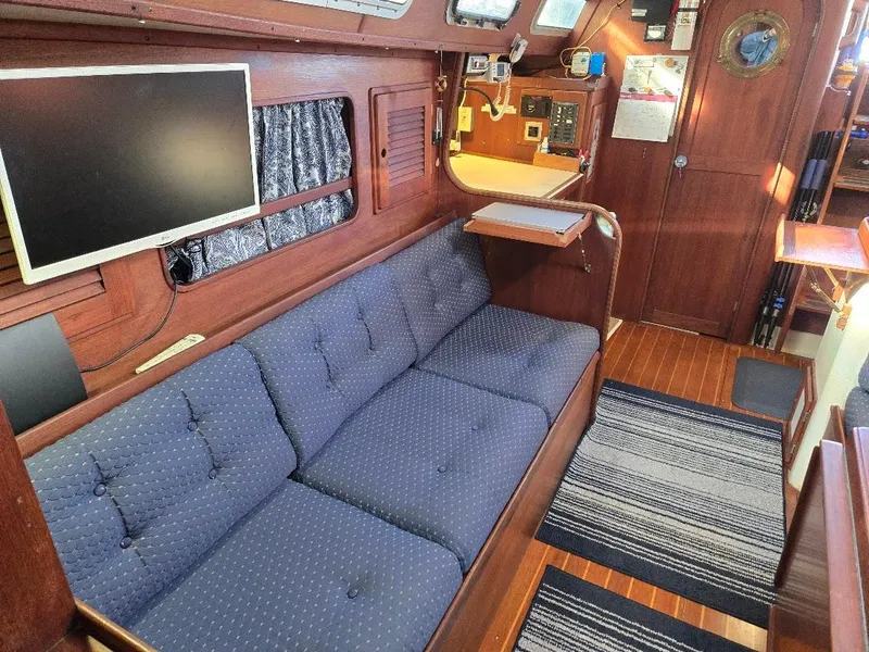 Slide: The Image of Interior of 1991 Freedom F-38 yacht with blue sofa, TV, and wooden decor. - 2