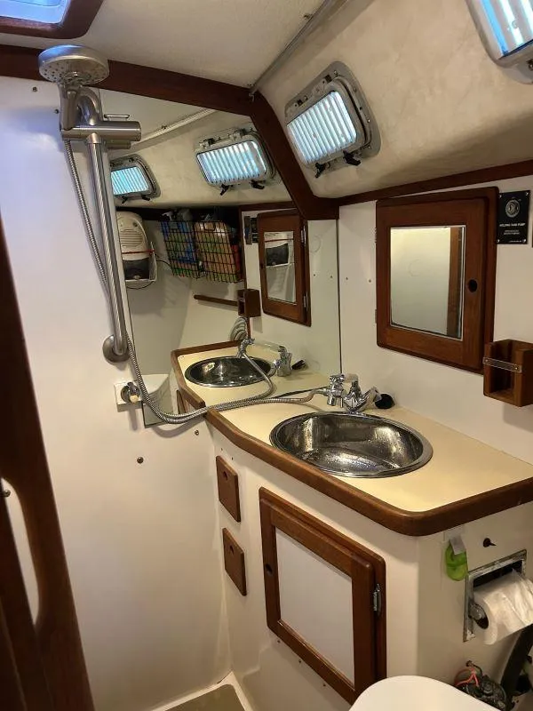 Slide: The Image of Compact 1991 Freedom F-38 boat bathroom with sink, mirror, and showerhead. - 21