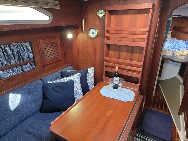 Slide: The Image of Cozy 1991 Freedom F-38 yacht interior with wooden dining area and nautical decor. - 22