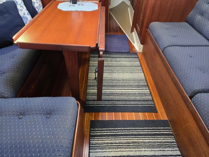 Slide: The Image of Interior of 1991 Freedom F-38 yacht with wooden table, striped rugs, and cushioned seating. - 27
