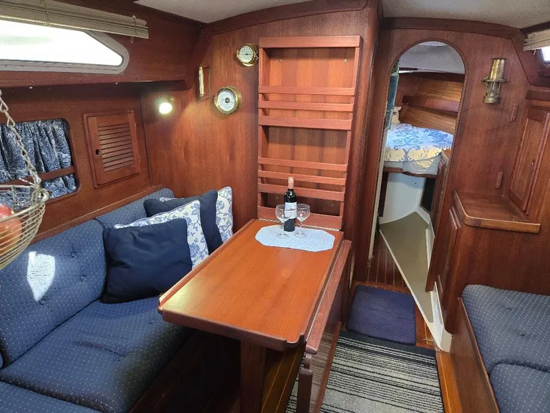 Slide: The Image of Cozy 1991 Freedom F-38 yacht interior with wooden decor and dining area. - 3