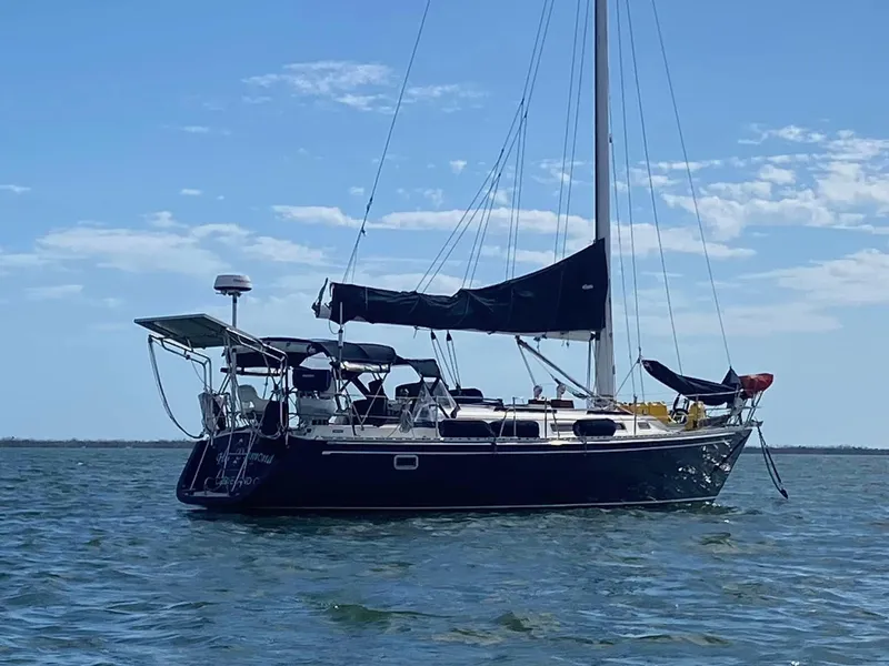 Slide: The Image of Sailboat Freedom F-38, 1991 model, anchored on calm water under a clear sky. - 53