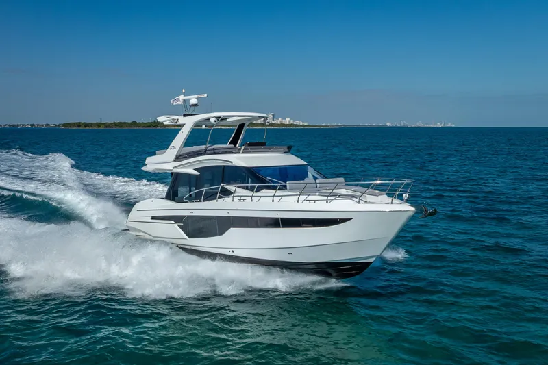 Slide: The Image of 2021 Galeon 500 Fly yacht cruising on open water under clear blue skies. - 4