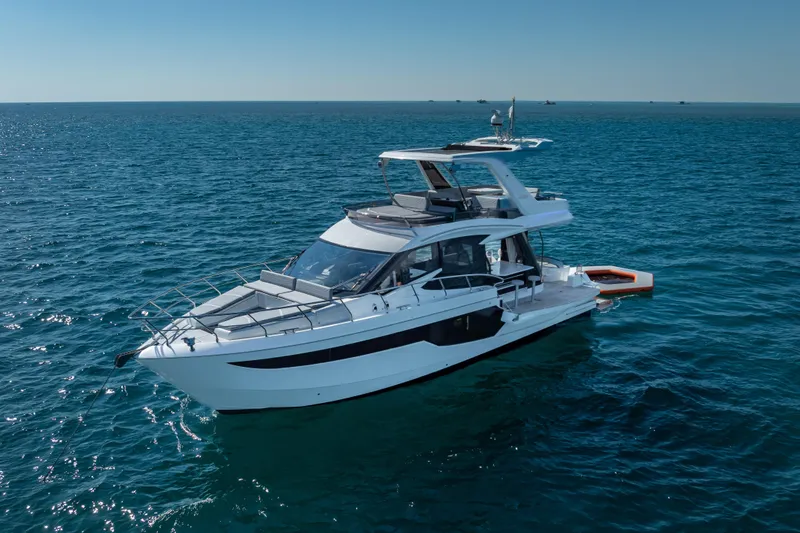 Slide: The Image of 2021 Galeon 500 Fly yacht cruising on open sea under clear blue sky. - 7
