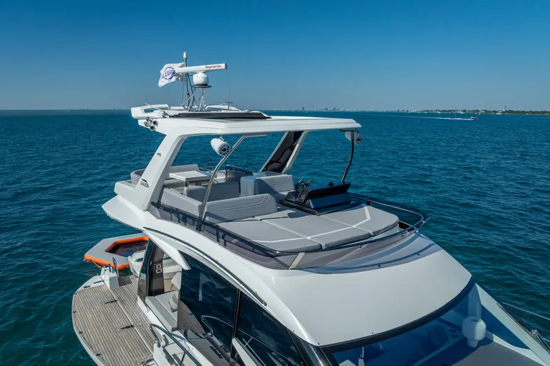 Slide: The Image of 2021 Galeon 500 Fly yacht cruising on open water under clear blue skies. - 9