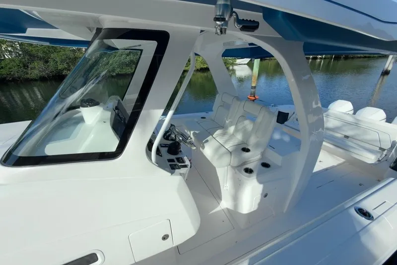 Slide: The Image of 2022 Intrepid 407 Panacea boat interior with sleek white seating and modern controls. - 116