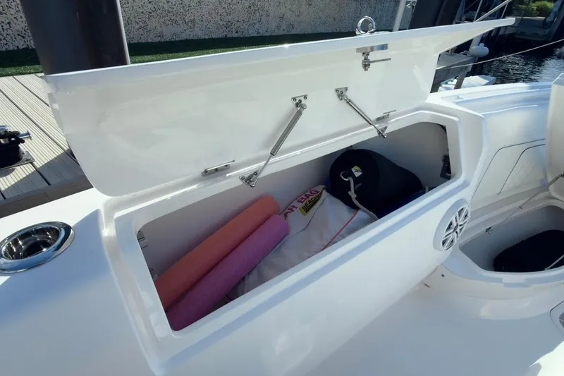 Slide: The Image of Open storage compartment on 2022 Intrepid 407 Panacea boat with pool noodles and gear. - 127