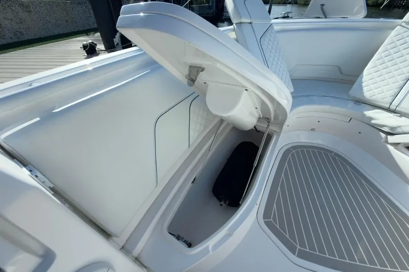Slide: The Image of 2022 Intrepid 407 Panacea boat interior with open storage compartment and cushioned seating. - 129