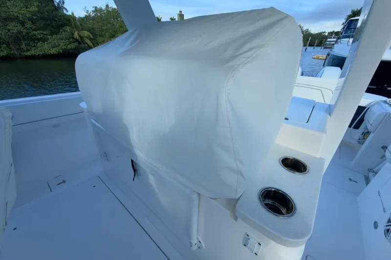 Slide: The Image of 2022 Intrepid 407 Panacea boat interior with covered seating and cup holders. - 13