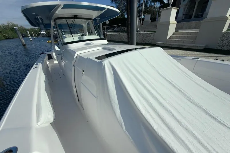 Slide: The Image of 2022 Intrepid 407 Panacea boat docked, showcasing sleek design and spacious deck. - 14