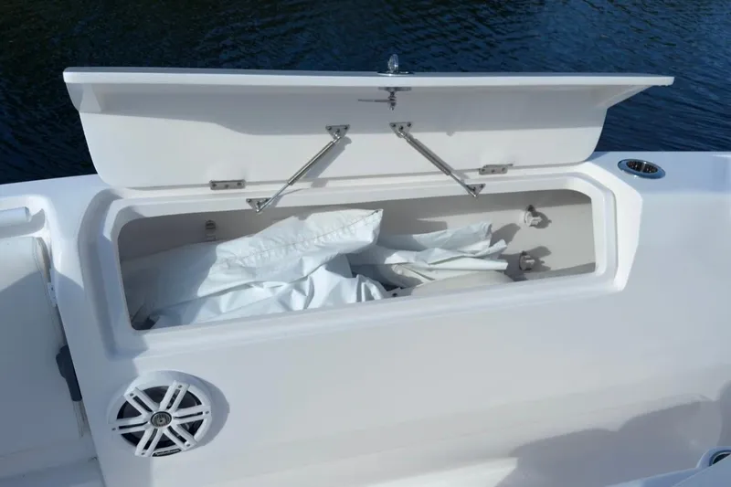 Slide: The Image of Open storage compartment on 2022 Intrepid 407 Panacea boat, featuring white interior and speaker. - 143