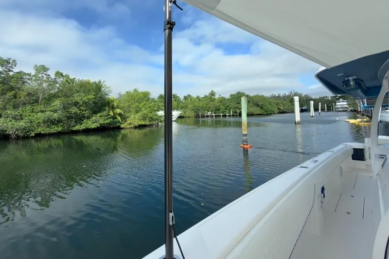 Slide: The Image of 2022 Intrepid 407 Panacea boat docked in a serene, lush riverside setting. - 153