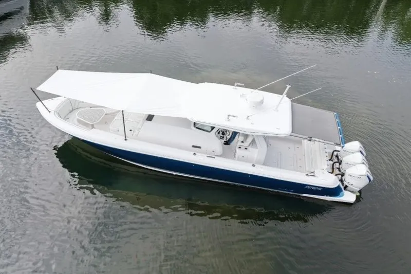 Slide: The Image of 2022 Intrepid 407 Panacea boat with canopy, docked on calm water. - 155