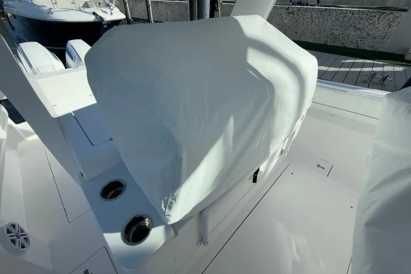 Slide: The Image of 2022 Intrepid 407 Panacea boat interior with covered seating and cup holders. - 16