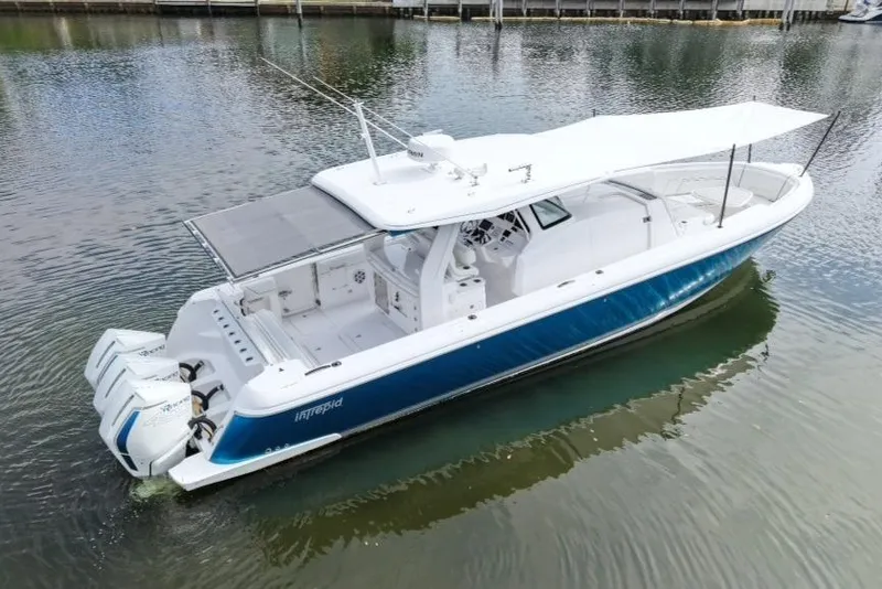 Slide: The Image of 2022 Intrepid 407 Panacea boat with triple engines, docked on calm water. - 162