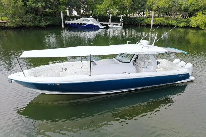 Slide: The Image of 2022 Intrepid 407 Panacea boat with canopy, docked on calm water. - 166