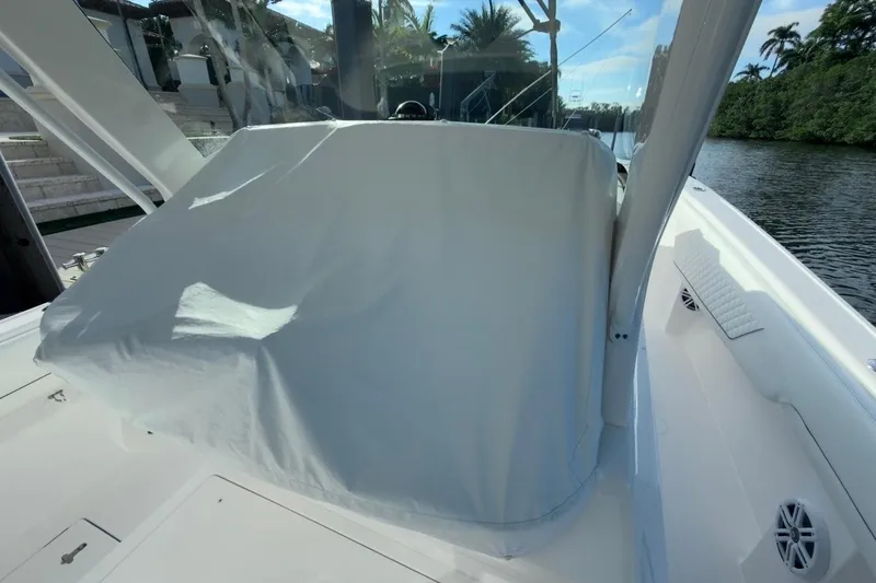 Slide: The Image of 2022 Intrepid 407 Panacea boat with covered console, docked by a scenic waterway. - 18