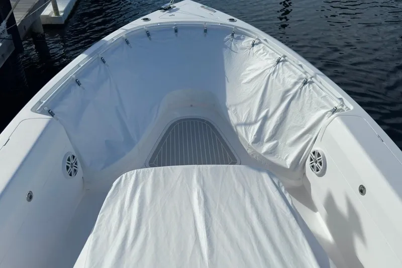 Slide: The Image of 2022 Intrepid 407 Panacea boat interior with white seating and water backdrop. - 19