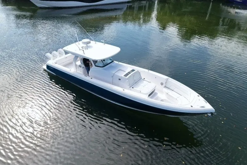 Slide: The Image of 2022 Intrepid 407 Panacea boat on calm water, showcasing sleek design and spacious deck. - 2