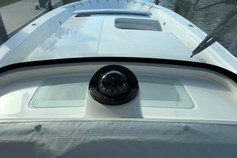 Slide: The Image of 2022 Intrepid 407 Panacea boat with compass on deck, docked by water. - 23