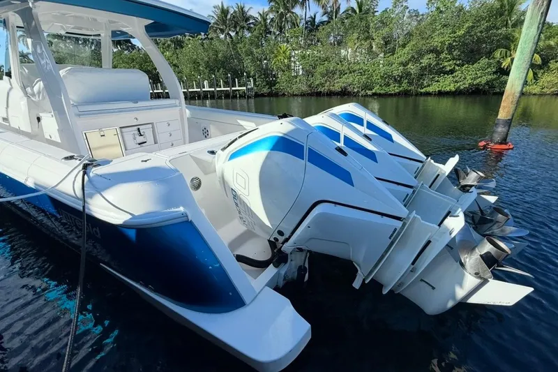 Slide: The Image of 2022 Intrepid 407 Panacea boat with triple outboard engines, docked in a serene waterway. - 24