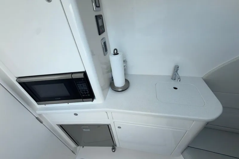 Slide: The Image of 2022 Intrepid 407 Panacea interior with microwave, sink, and storage. - 33