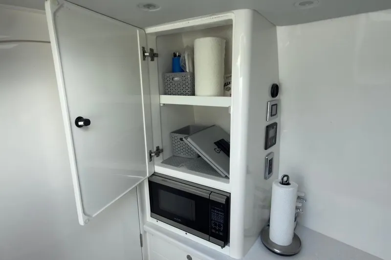 Slide: The Image of Cabinet interior with microwave and storage in 2022 Intrepid 407 Panacea boat. - 35