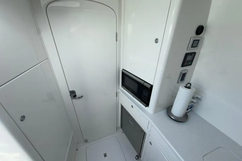 Slide: The Image of 2022 Intrepid 407 Panacea interior with microwave, storage, and sleek white design. - 36