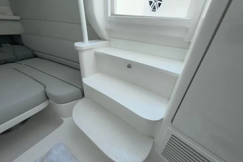 Slide: The Image of Interior of 2022 Intrepid 407 Panacea, featuring sleek white steps and cushioned seating. - 44