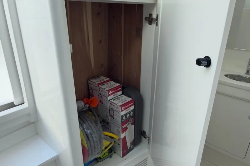 Slide: The Image of Storage compartment on 2022 Intrepid 407 Panacea boat with safety equipment and supplies. - 45