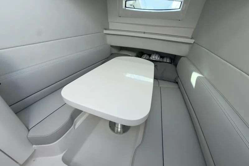 Slide: The Image of Interior of 2022 Intrepid 407 Panacea boat with sleek white seating and table. - 47