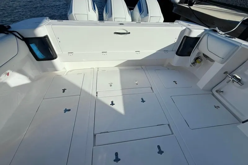 Slide: The Image of 2022 Intrepid 407 Panacea boat deck with storage compartments and triple engines. - 50