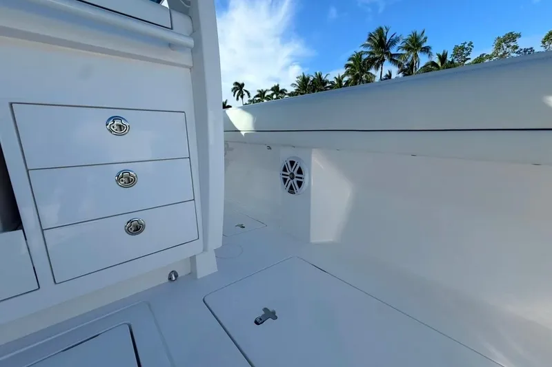 Slide: The Image of 2022 Intrepid 407 Panacea boat interior with storage drawers and speaker, under clear blue sky. - 54