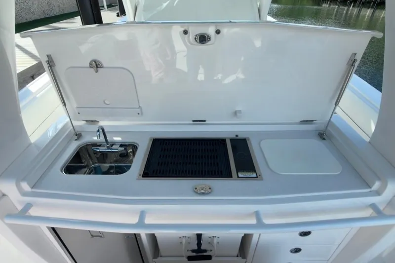 Slide: The Image of 2022 Intrepid 407 Panacea boat kitchen with sink, grill, and storage. - 60