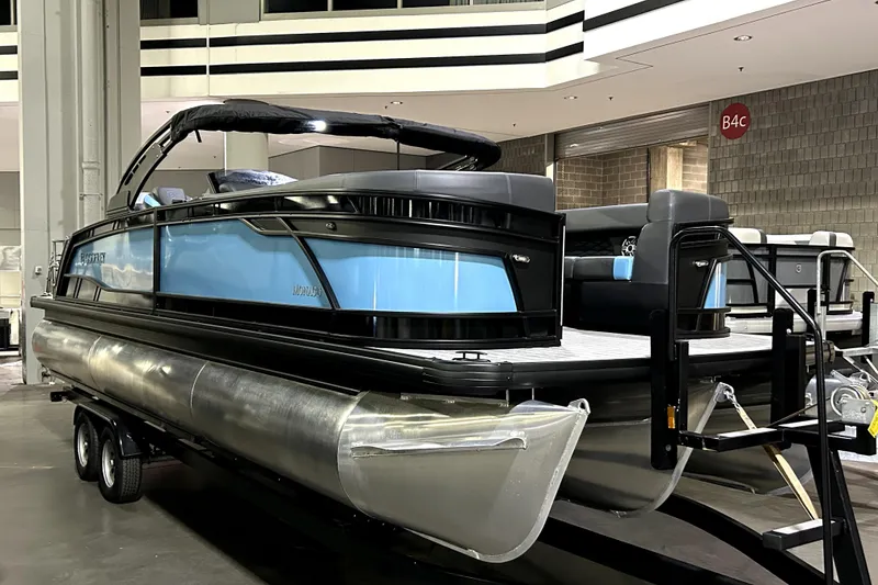 Slide: The Image of 2026 Godfrey Monaco 255 SFL pontoon boat displayed indoors on a trailer. - 0